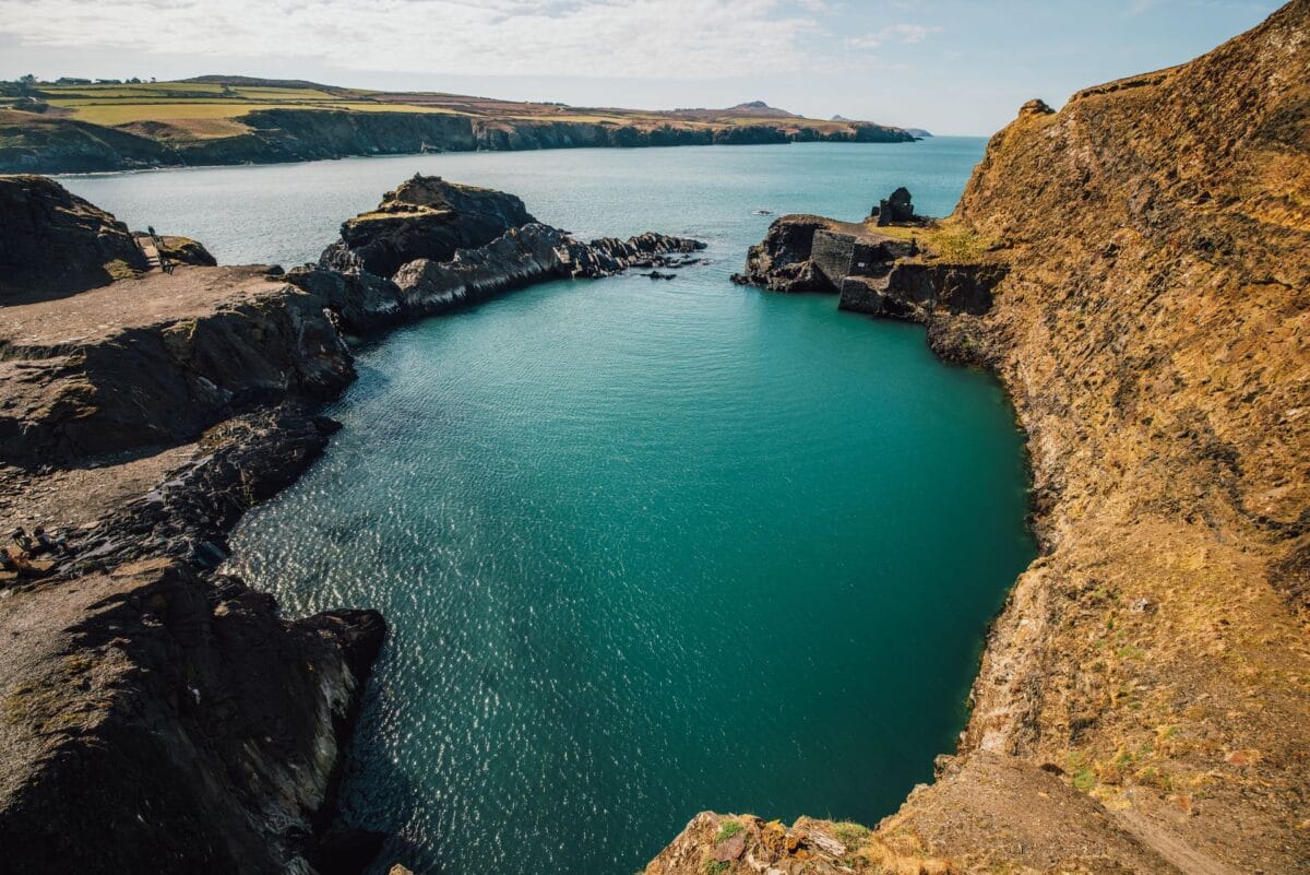 The vibrant turquoise waters of the Blue Lagoon at Abereiddi, a historic flooded slate quarry surrounded by rugged cliffs. Visiting this stunning spot is one of the best things to do in Pembrokeshire.