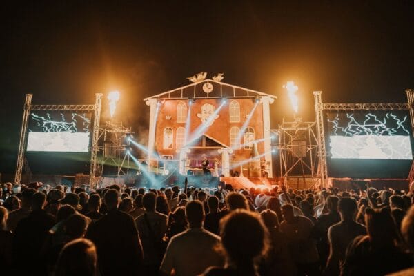 crowd watching and dancing to a band playing on stage at the Balter Festival