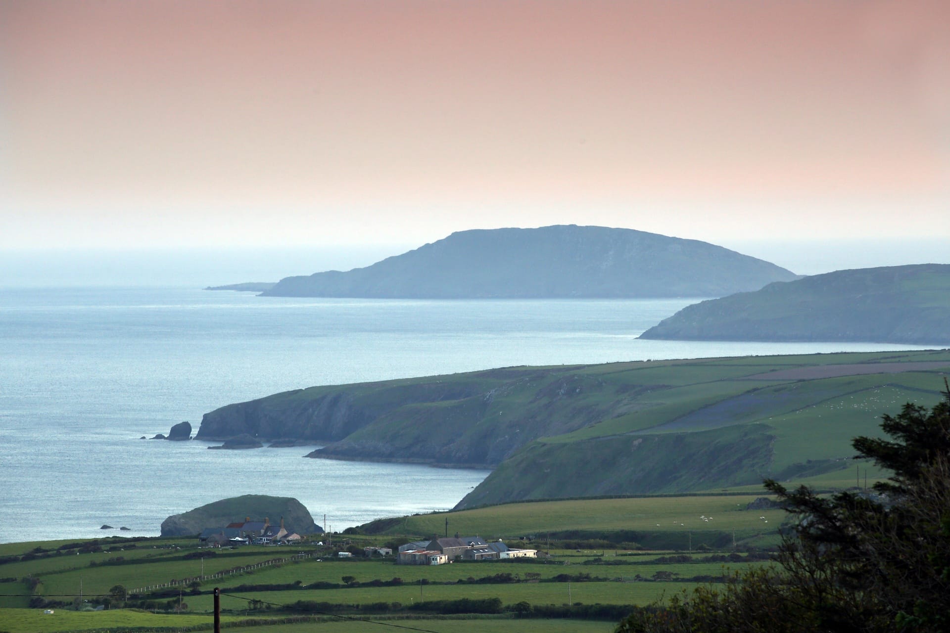 Final Destination point of The Pilgrims Way - Bardsey Island at sunset with a pink sky