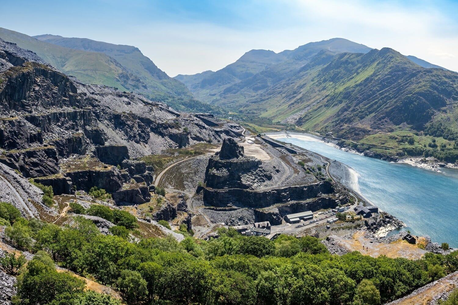 The vast terraced slate quarry workings at Dinorwig above Llyn Peris and the village of Llanberis, with the slopes of Yr Wyddfa rising behind