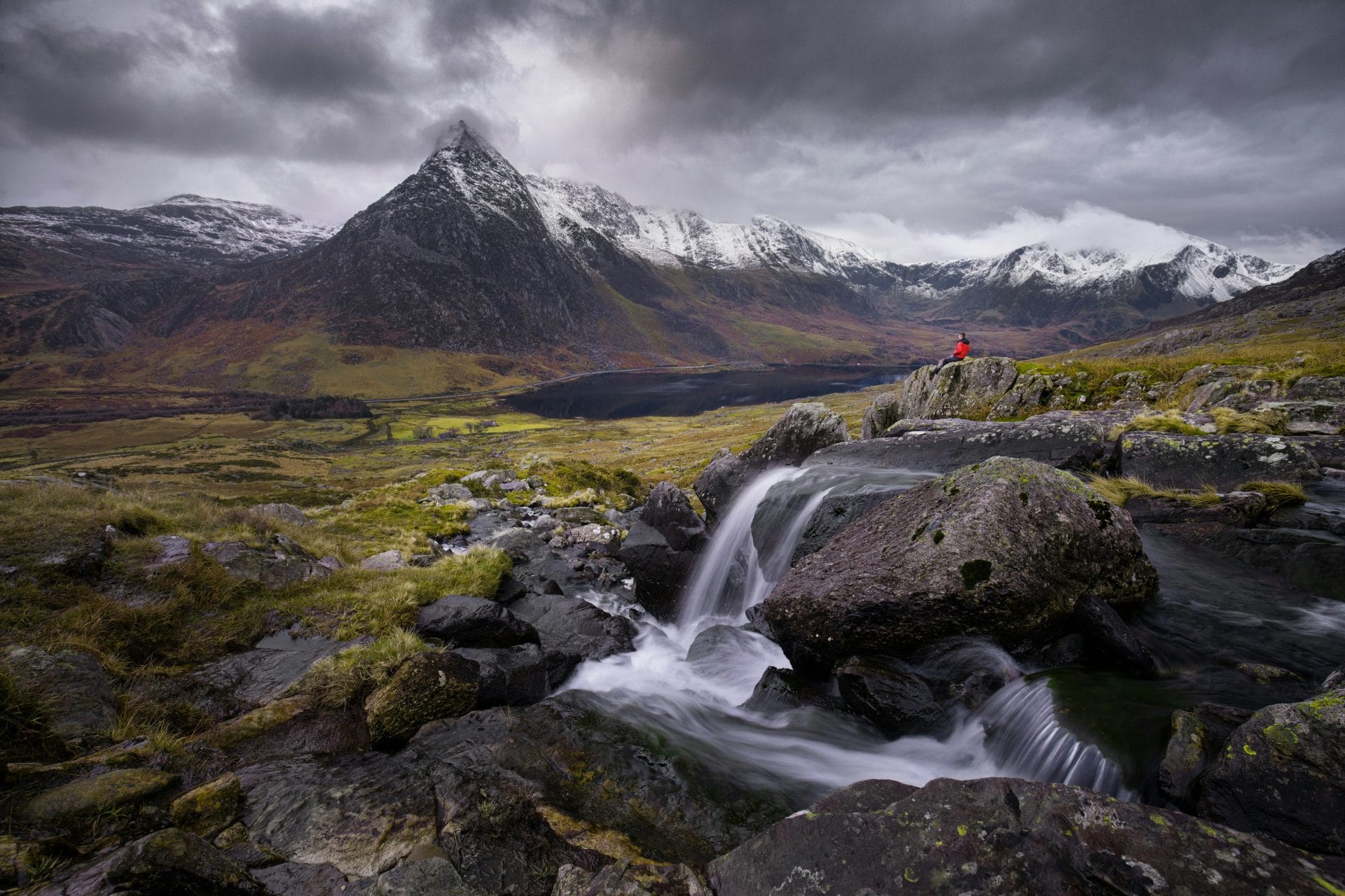 Tryfan mountain and a hiker  on a dark cloudy day