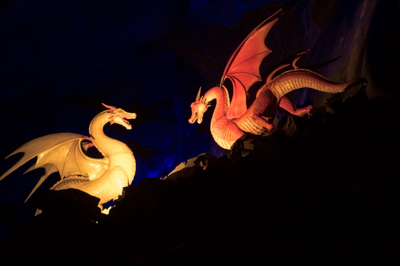 2 lit up dragons facing each other at night