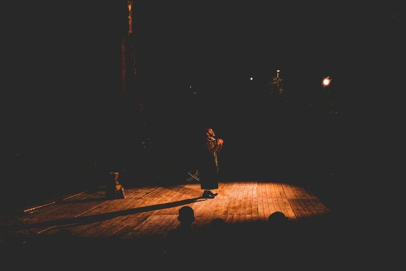 Man performing on stage at a theatre
