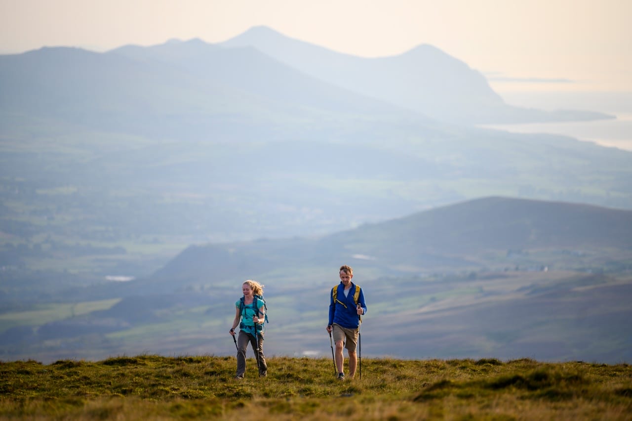 Two hikers in Snowdonia National with Snowdonia in the background