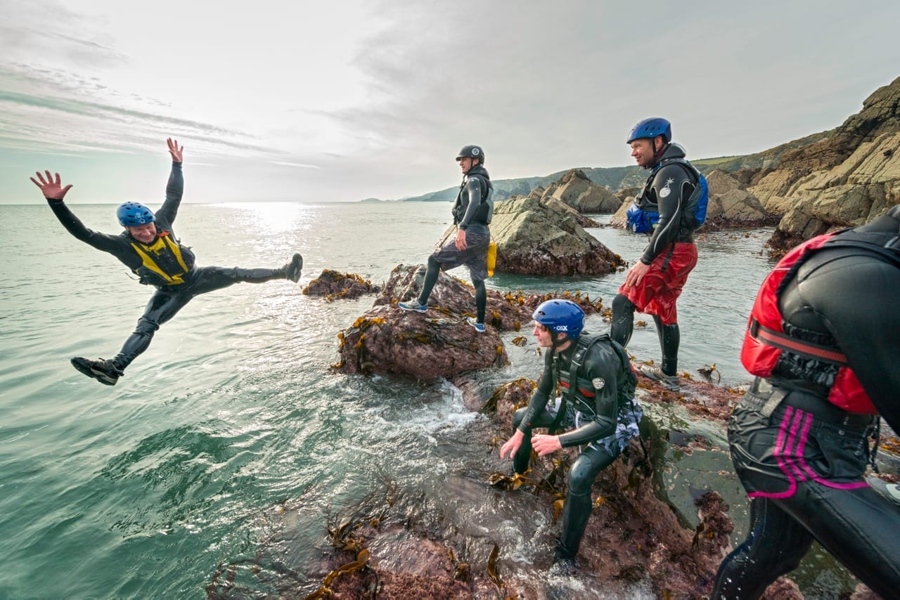 Group of people having Coasteering adventures in Wales near St Davids on the south coast