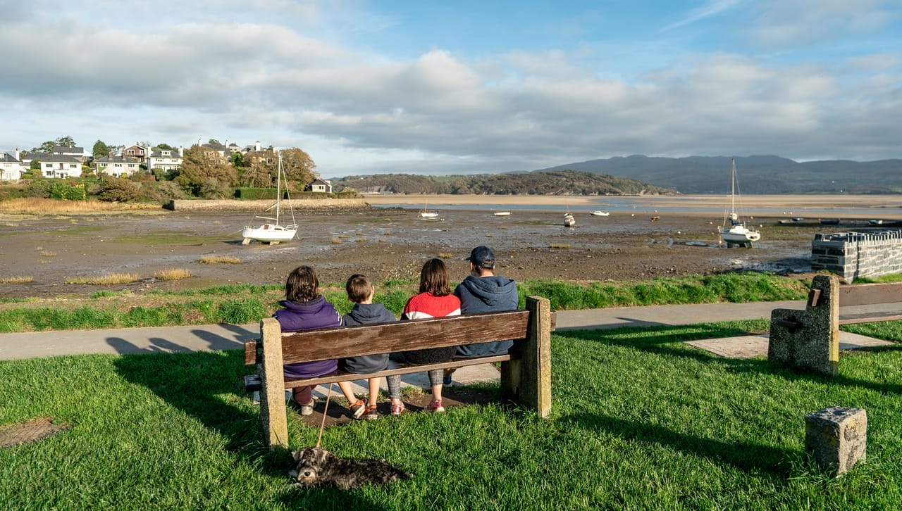 Family sitting on bench overlooking the sea near Porthmadog