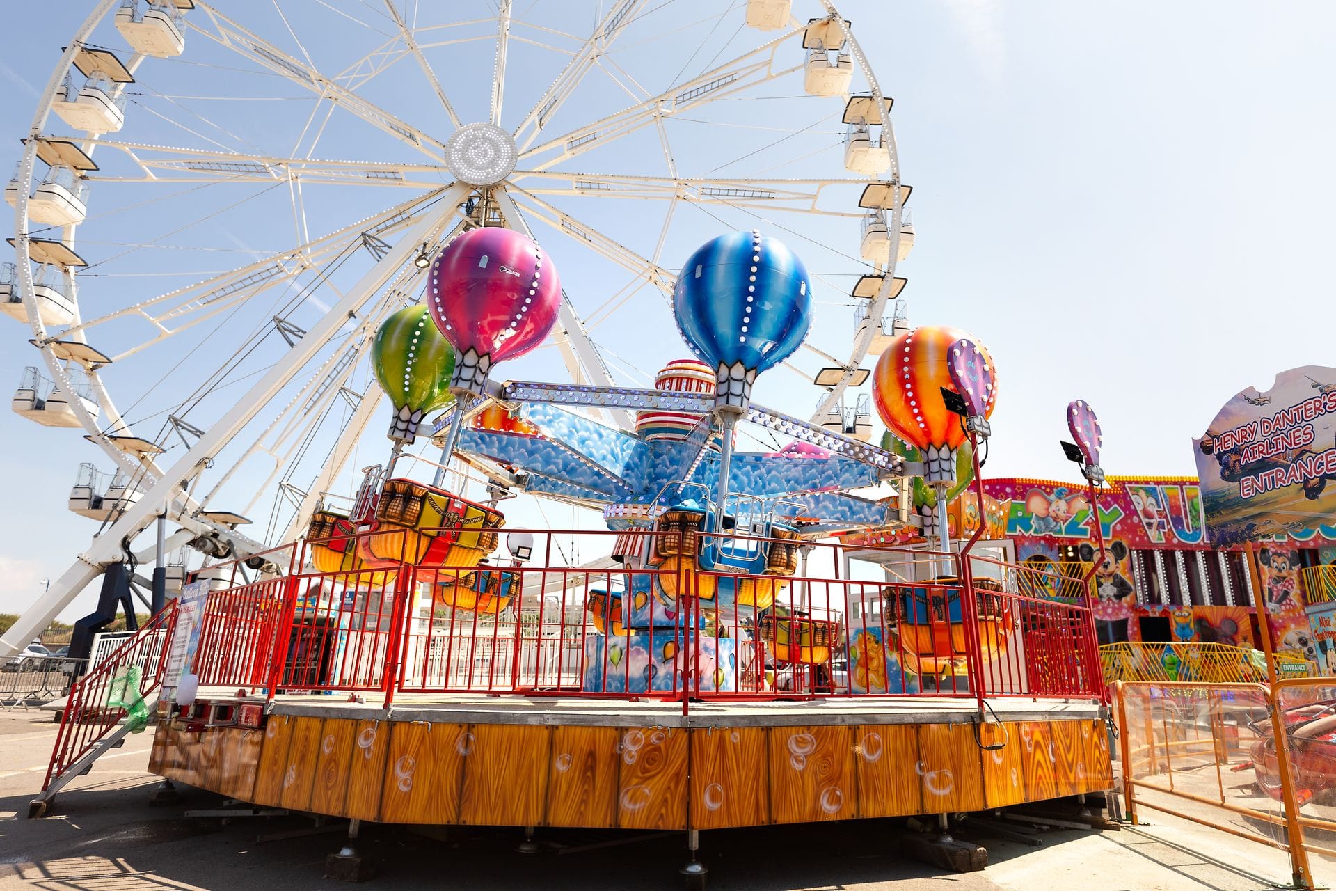 Colourful fairground rides including a Ferris wheel at Barry Island Pleasure Park, Wales