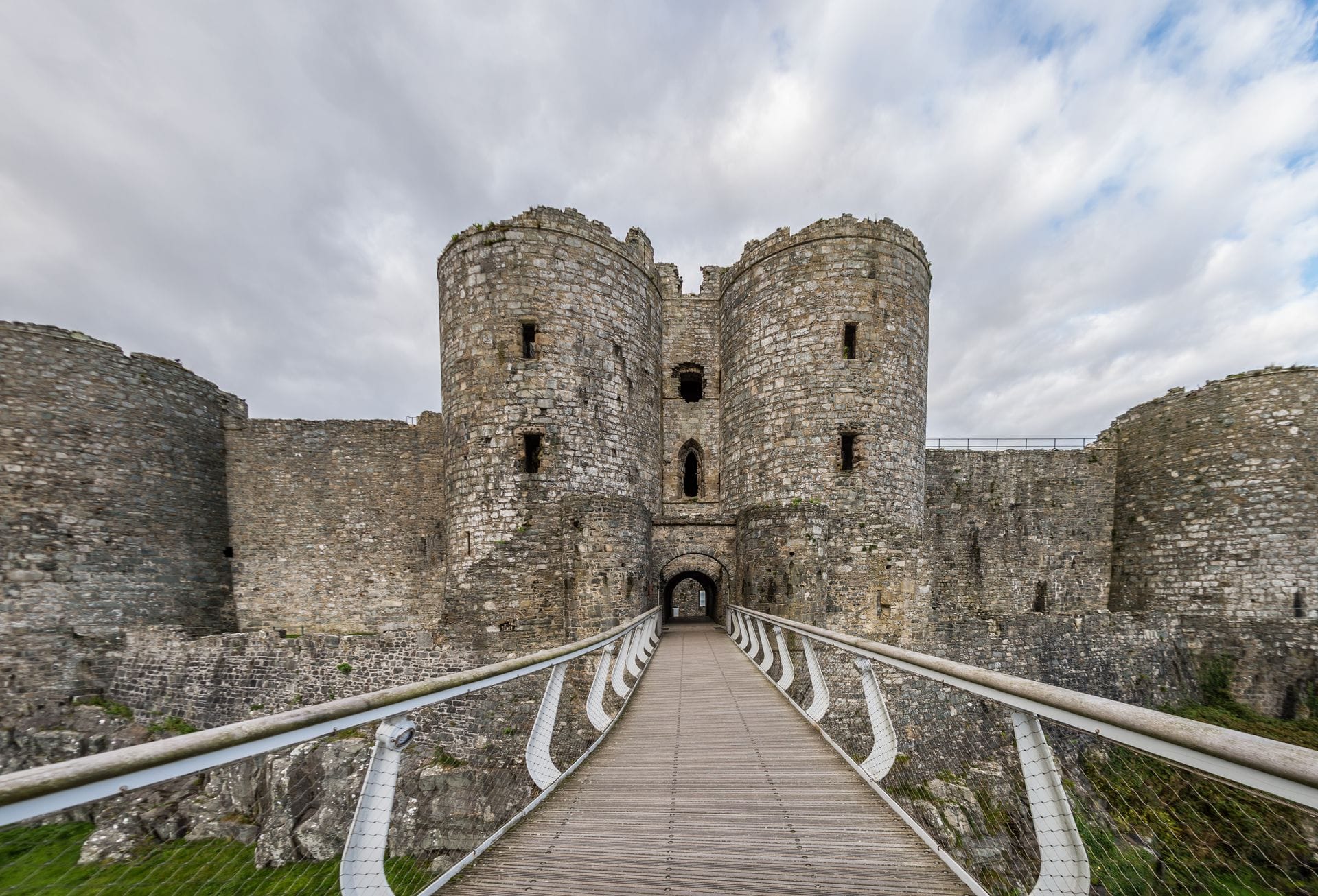 The massive twin drum towers of Harlech Castle's east gatehouse, the most heavily defended entrance of the fortress, seen from the approach path.