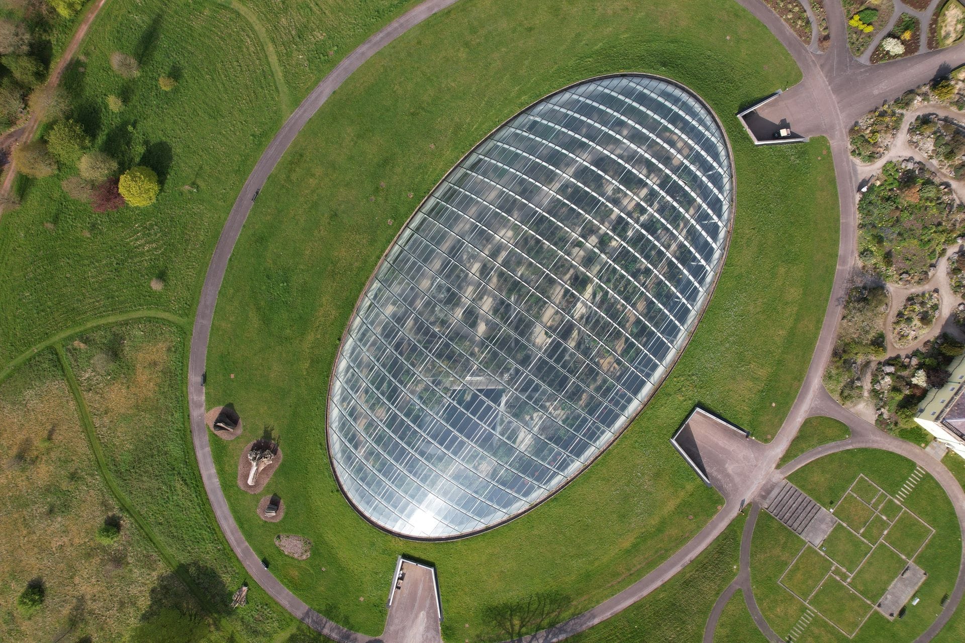The impressive exterior of the Norman Foster-designed Great Glasshouse at the National Botanic Garden of Wales, showing its iconic sweeping glass roof.