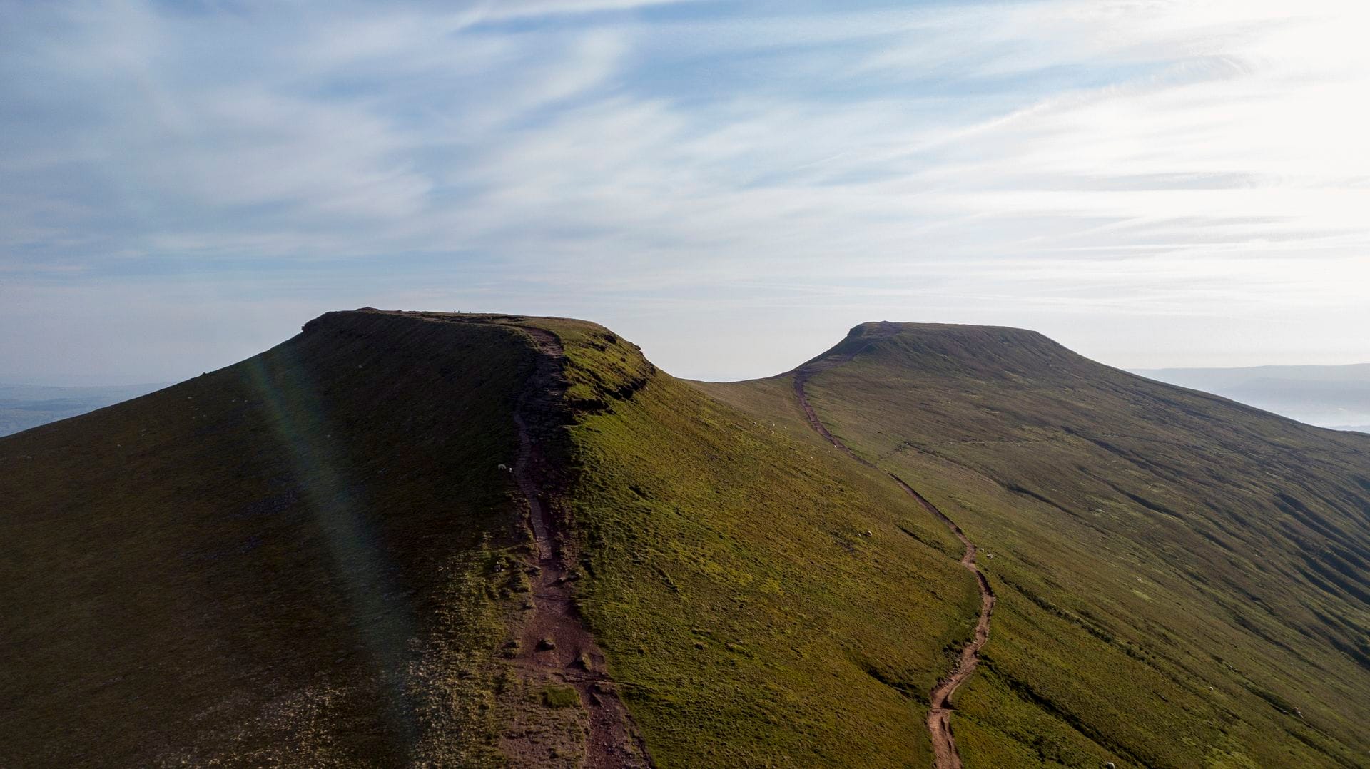 Walkers ascending the well-maintained stone footpath on the popular Motorway route up Pen y Fan mountain in summer.