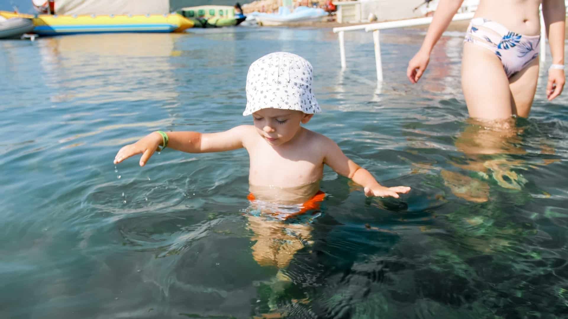 3 years old toddler boy paddling in Wales