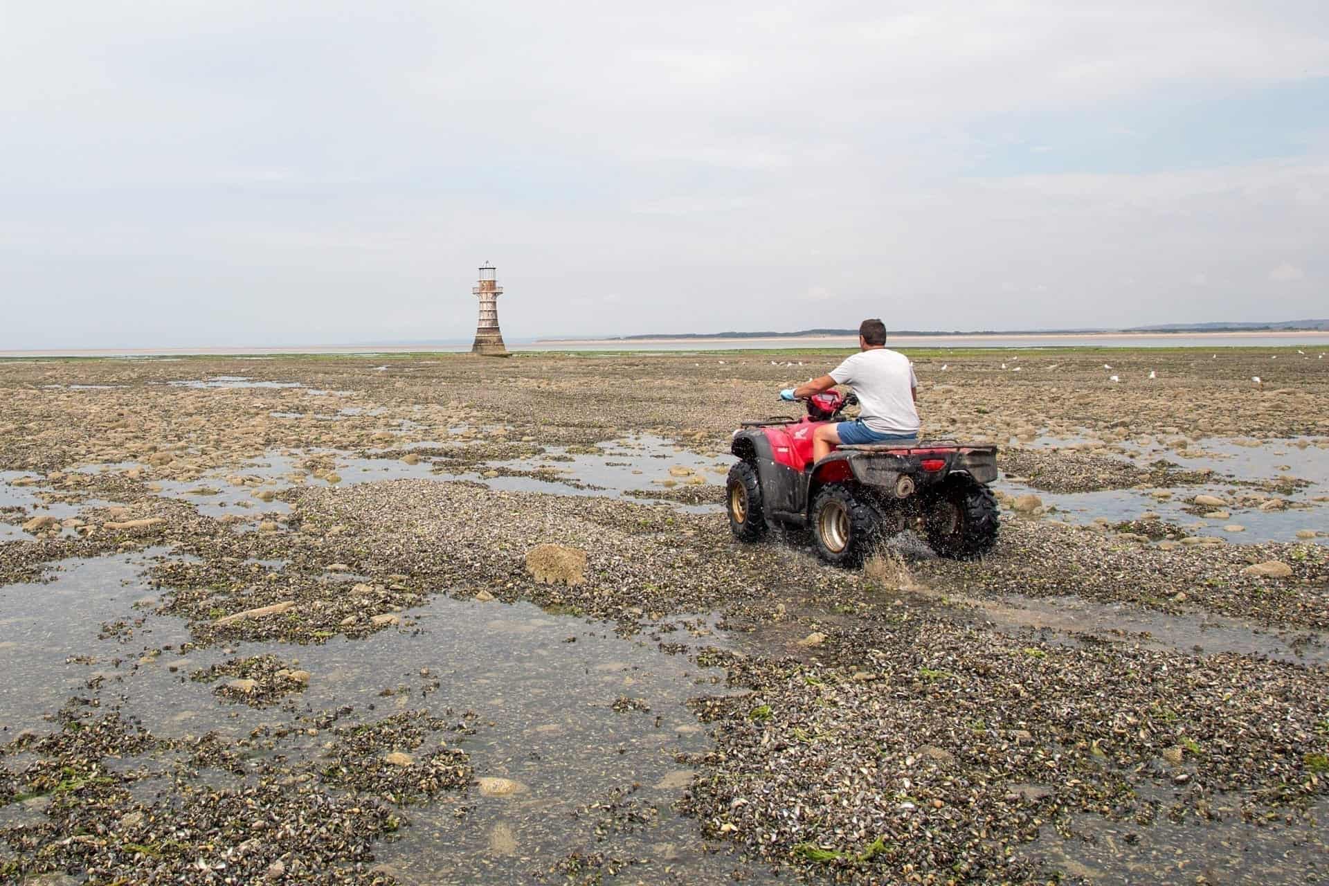 man on a quad bike on a beach in Wales