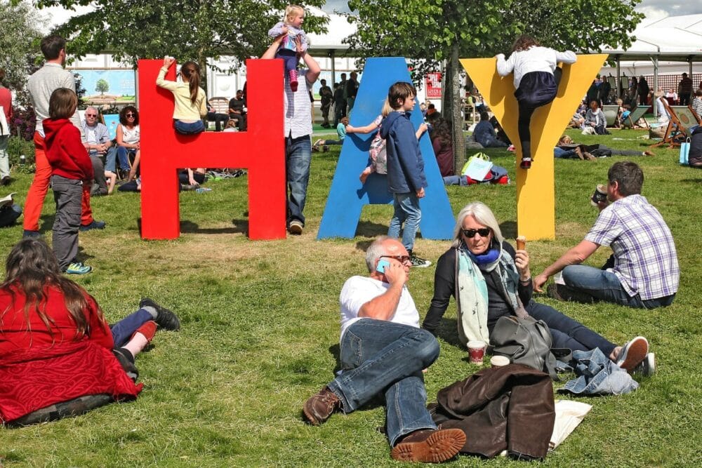 People sitting on the grass and relaxing at the Hay Festival in Wales