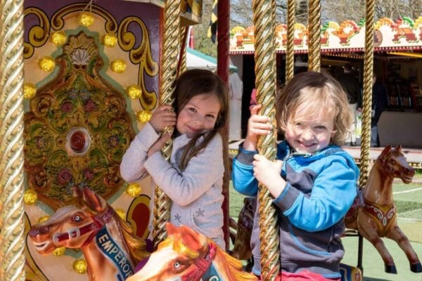 two girls on a carousel ride, riding horses in Cardiff